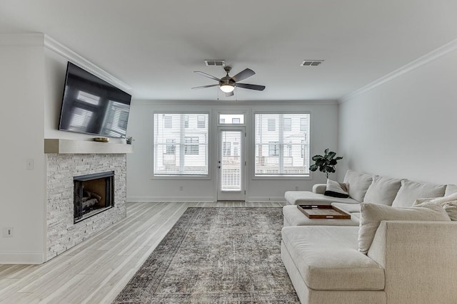 1117 Larkin Dr, Buford, GA 30518 - living room featuring ceiling fan, wood finished floors, a stone fireplace, ornamental molding, and baseboards