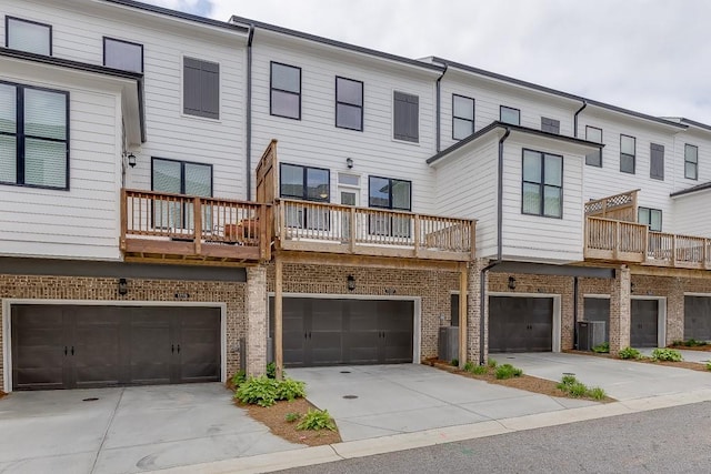 1117 Larkin Dr, Buford, GA 30518 - back of house featuring a garage, driveway, and brick siding