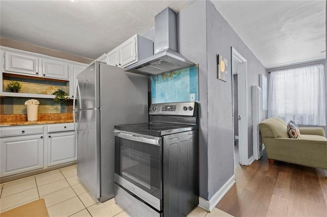 210 Estoria St SE, Atlanta, GA 30316 - kitchen with appliances with stainless steel finishes, wall chimney exhaust hood, white cabinetry, and baseboards