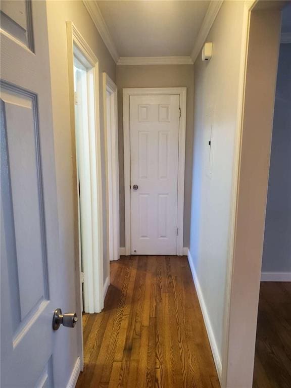 corridor featuring crown molding, wood finished floors, and baseboards