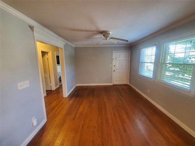 spare room featuring baseboards, a ceiling fan, wood finished floors, and crown molding