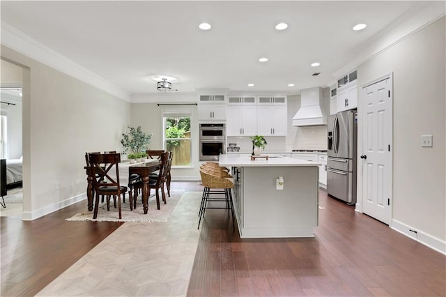 1105 Sterling Brooke Dr, Alpharetta, GA 30022 - kitchen featuring premium range hood, stainless steel appliances, crown molding, a kitchen island with sink, and light countertops