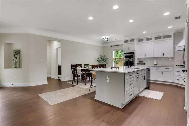1105 Sterling Brooke Dr, Alpharetta, GA 30022 - kitchen with light countertops, dark wood-style floors, white cabinets, a kitchen island with sink, and crown molding