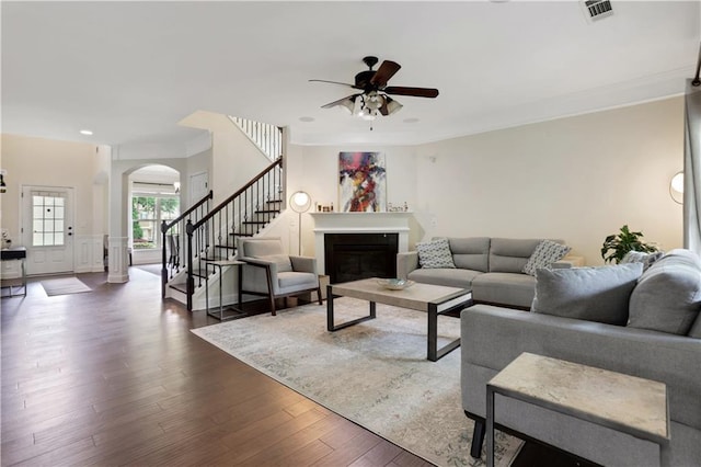 1105 Sterling Brooke Dr, Alpharetta, GA 30022 - living room with arched walkways, a ceiling fan, stairs, a fireplace, and wood finished floors
