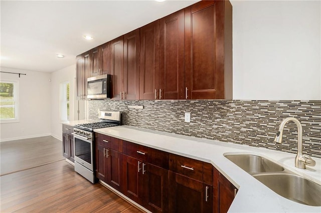 2308 Scotty Cir, Decatur, GA 30032 - kitchen featuring appliances with stainless steel finishes, a sink, dark wood-type flooring, decorative backsplash, and light countertops