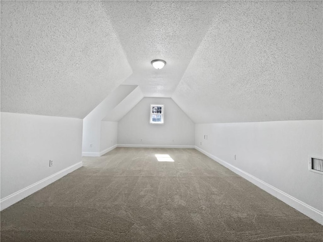 bonus room featuring lofted ceiling, carpet floors, and a textured ceiling