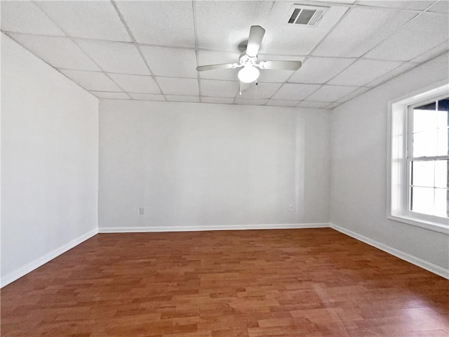 empty room with hardwood / wood-style flooring, a paneled ceiling, and ceiling fan