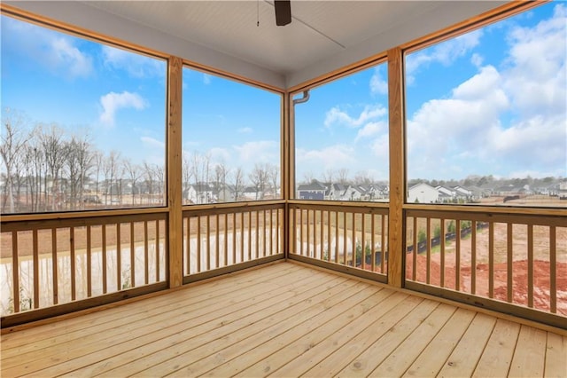 unfurnished sunroom featuring ceiling fan