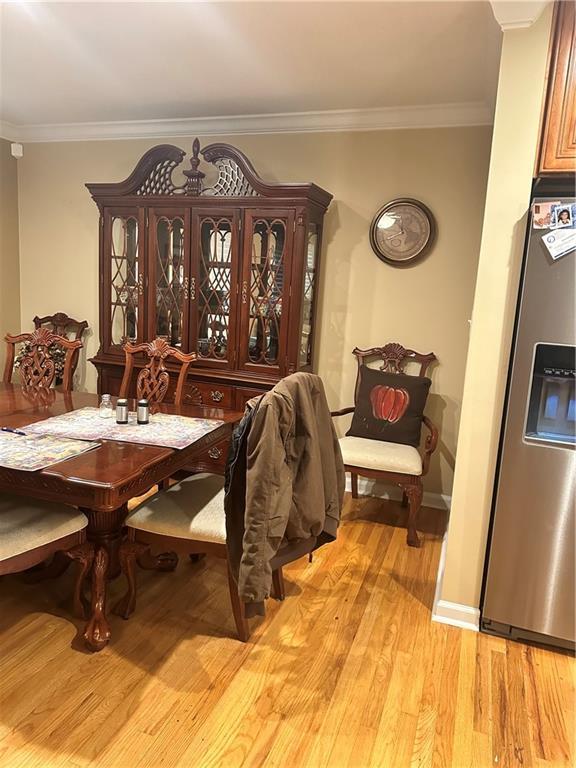 dining area with crown molding and light hardwood / wood-style floors