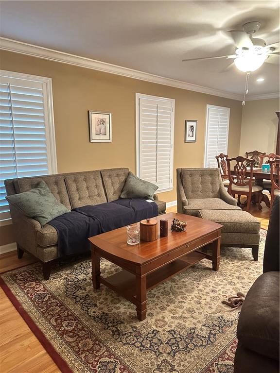 living room featuring ceiling fan, crown molding, and hardwood / wood-style floors