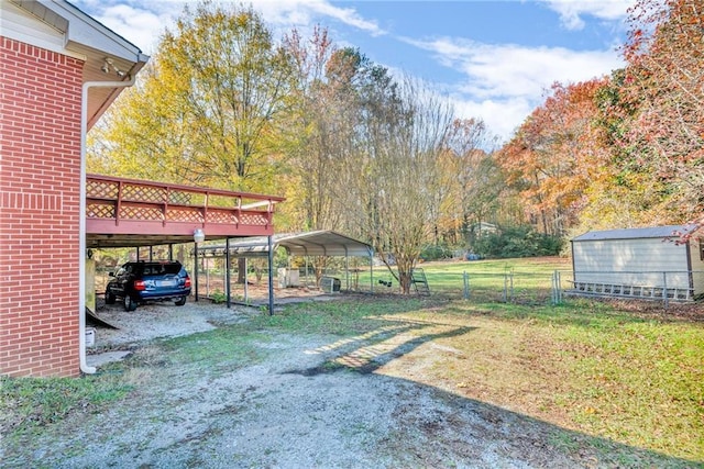 view of yard featuring a deck, a storage shed, and a carport