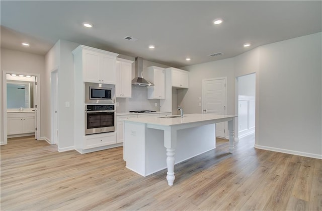 0 Cooper Cv E, Fayetteville, GA 30215 - kitchen featuring stainless steel appliances, wall chimney exhaust hood, a sink, light wood-type flooring, and recessed lighting