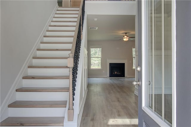 0 Cooper Cv E, Fayetteville, GA 30215 - stairs featuring a ceiling fan, wood finished floors, a lit fireplace, and baseboards
