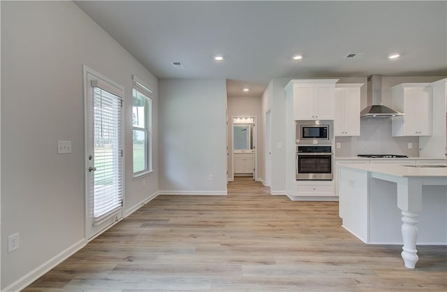 0 Cooper Cv E, Fayetteville, GA 30215 - kitchen featuring wall chimney exhaust hood, appliances with stainless steel finishes, baseboards, light wood finished floors, and white cabinetry