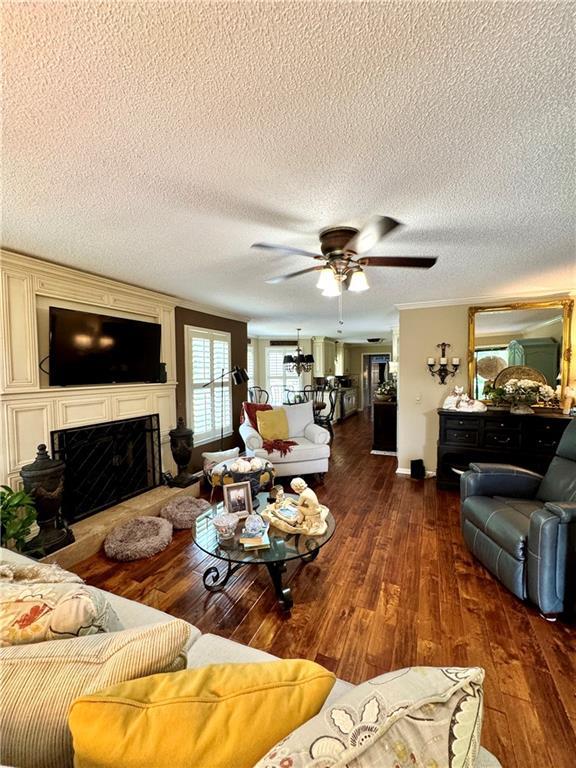270 Owens Cir NE, Calhoun, GA 30701 - living area with a textured ceiling, a fireplace with raised hearth, hardwood / wood-style floors, and ceiling fan