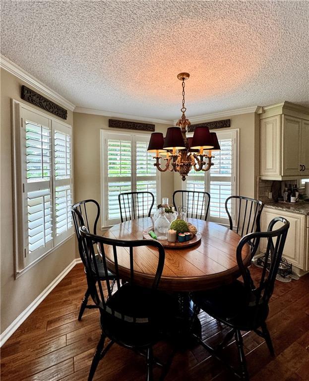 270 Owens Cir NE, Calhoun, GA 30701 - dining room with a chandelier, healthy amount of natural light, a textured ceiling, dark wood-style floors, and ornamental molding
