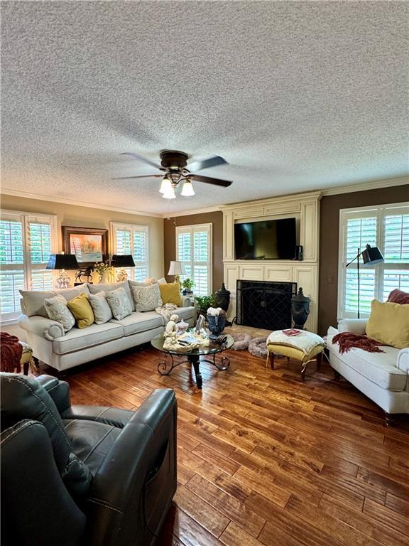 270 Owens Cir NE, Calhoun, GA 30701 - living room featuring crown molding, plenty of natural light, wood finished floors, a textured ceiling, and ceiling fan