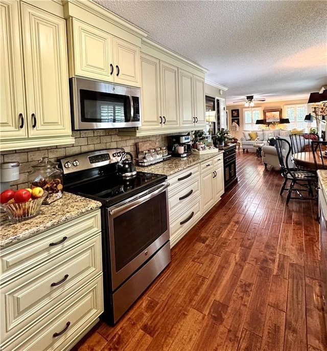 270 Owens Cir NE, Calhoun, GA 30701 - kitchen with appliances with stainless steel finishes, cream cabinets, open floor plan, dark wood-type flooring, and a textured ceiling