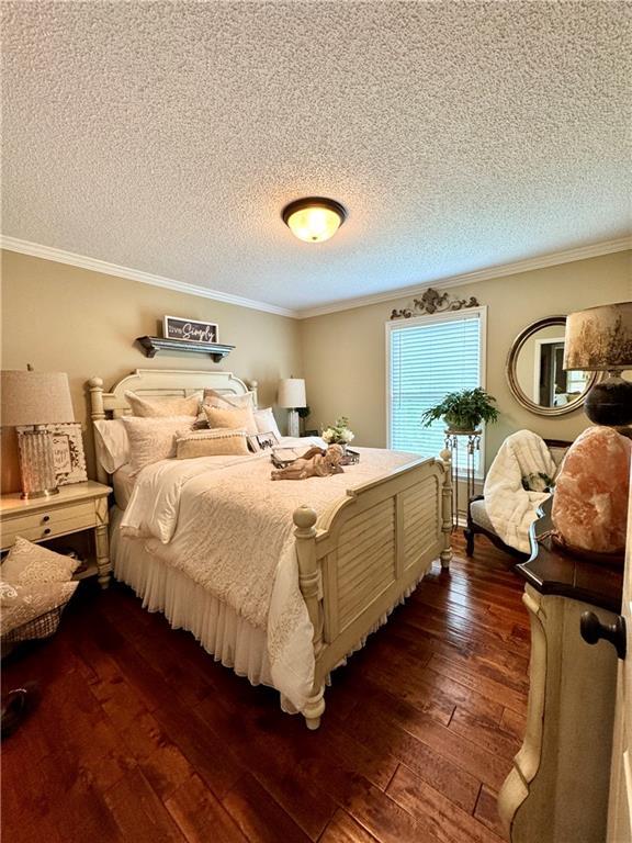 270 Owens Cir NE, Calhoun, GA 30701 - bedroom with dark wood finished floors, crown molding, and a textured ceiling