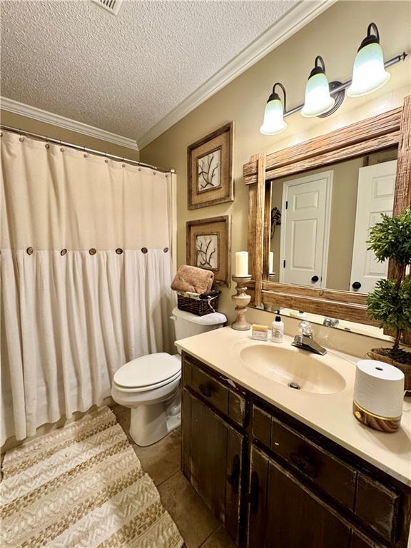 270 Owens Cir NE, Calhoun, GA 30701 - bathroom with a textured ceiling, toilet, ornamental molding, vanity, and tile patterned floors