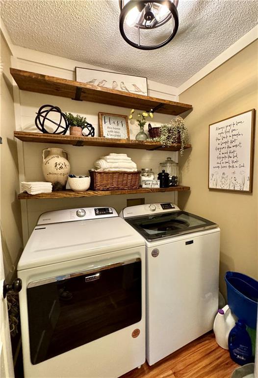 270 Owens Cir NE, Calhoun, GA 30701 - laundry room featuring washing machine and dryer, light wood-style floors, and a textured ceiling