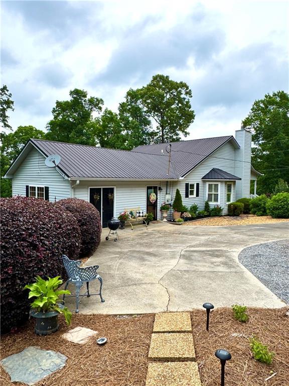 270 Owens Cir NE, Calhoun, GA 30701 - ranch-style house with metal roof and a patio