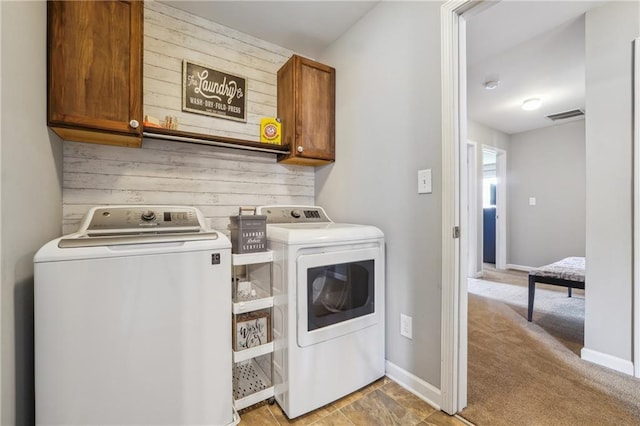 washroom featuring cabinets, independent washer and dryer, and light carpet