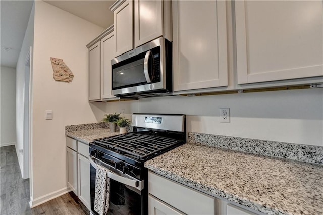 82 Graham Campbell Ln, Statham, GA 30666 - kitchen featuring appliances with stainless steel finishes, wood finished floors, baseboards, and light stone countertops