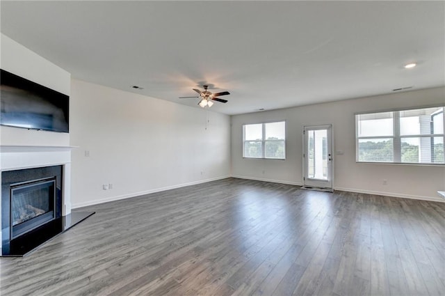 82 Graham Campbell Ln, Statham, GA 30666 - unfurnished living room featuring ceiling fan, a fireplace with raised hearth, dark wood finished floors, and baseboards