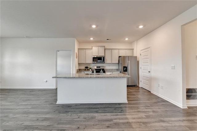82 Graham Campbell Ln, Statham, GA 30666 - kitchen featuring stainless steel appliances, baseboards, a kitchen island with sink, wood finished floors, and recessed lighting