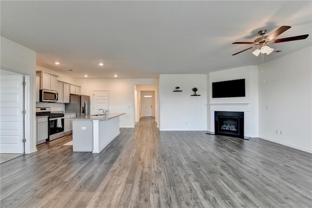 82 Graham Campbell Ln, Statham, GA 30666 - kitchen with stainless steel appliances, open floor plan, a center island with sink, a sink, and ceiling fan