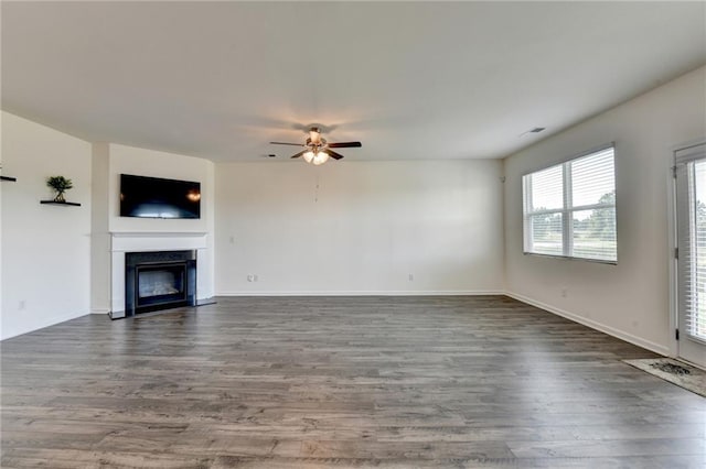 82 Graham Campbell Ln, Statham, GA 30666 - unfurnished living room featuring ceiling fan, dark wood-type flooring, a glass covered fireplace, and baseboards