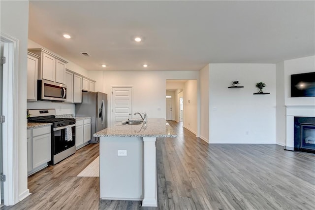 82 Graham Campbell Ln, Statham, GA 30666 - kitchen with appliances with stainless steel finishes, a sink, open floor plan, light wood-style floors, and recessed lighting