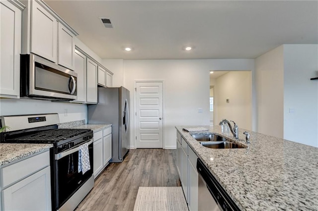82 Graham Campbell Ln, Statham, GA 30666 - kitchen with appliances with stainless steel finishes, a sink, light wood finished floors, light stone countertops, and recessed lighting