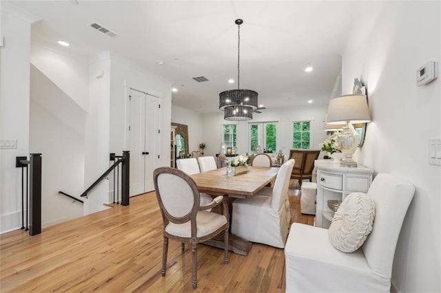 dining area featuring light hardwood / wood-style floors and a notable chandelier