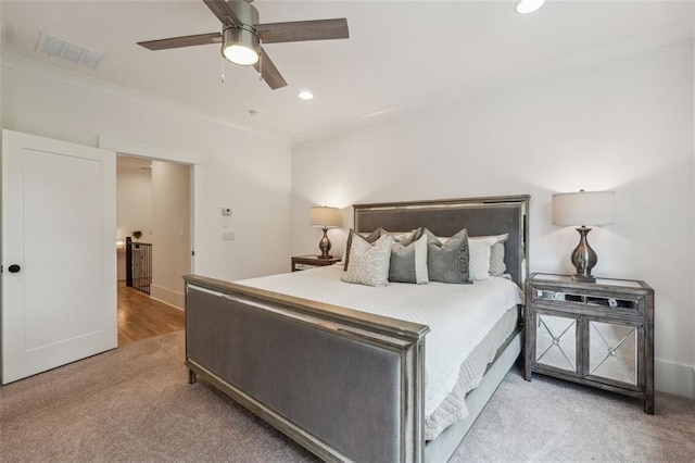 bedroom with ceiling fan, light carpet, and crown molding