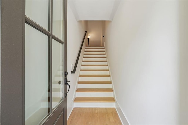 stairs featuring hardwood / wood-style floors