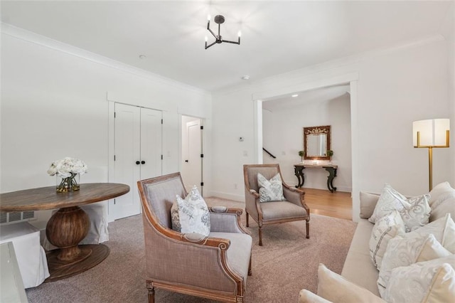 living area with ornamental molding, carpet, and a chandelier