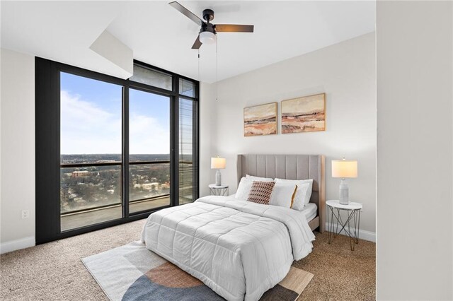 carpeted bedroom featuring ceiling fan, floor to ceiling windows, and baseboards