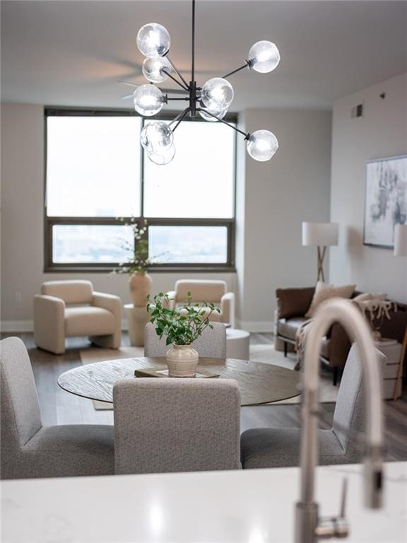 dining area featuring wood finished floors, visible vents, and baseboards