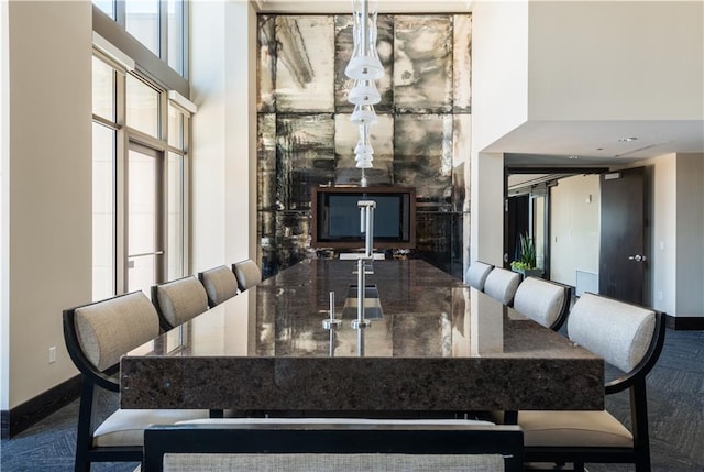 dining room featuring a towering ceiling and baseboards