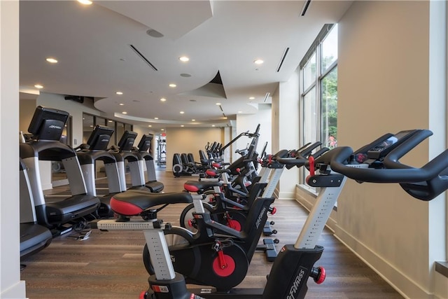 exercise room featuring recessed lighting, wood finished floors, and baseboards