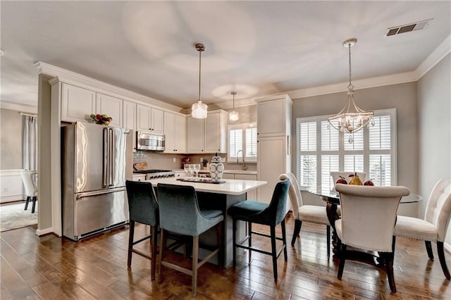 510 Elgaen Ct, Roswell, GA 30075 - kitchen with stainless steel appliances, white cabinetry, light countertops, crown molding, and dark wood-type flooring
