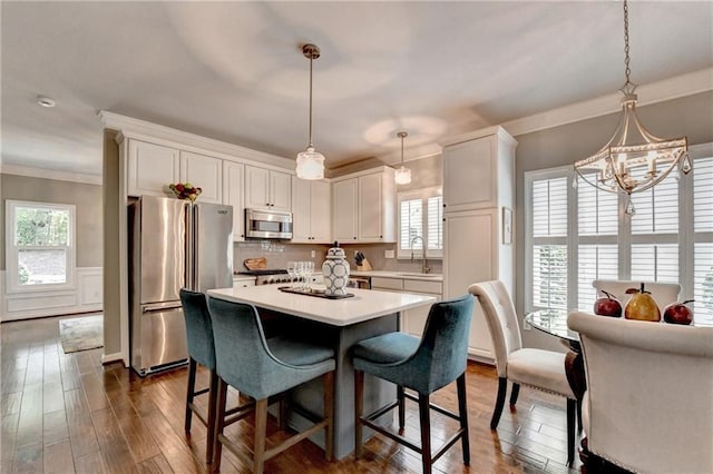 510 Elgaen Ct, Roswell, GA 30075 - kitchen with appliances with stainless steel finishes, ornamental molding, light countertops, a chandelier, and white cabinets