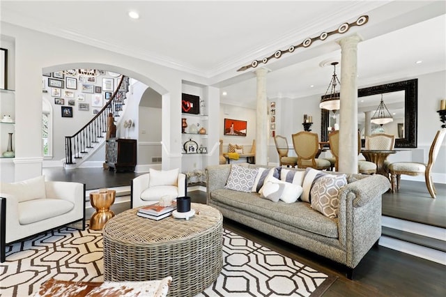 living room with built in features, decorative columns, ornamental molding, and hardwood / wood-style flooring