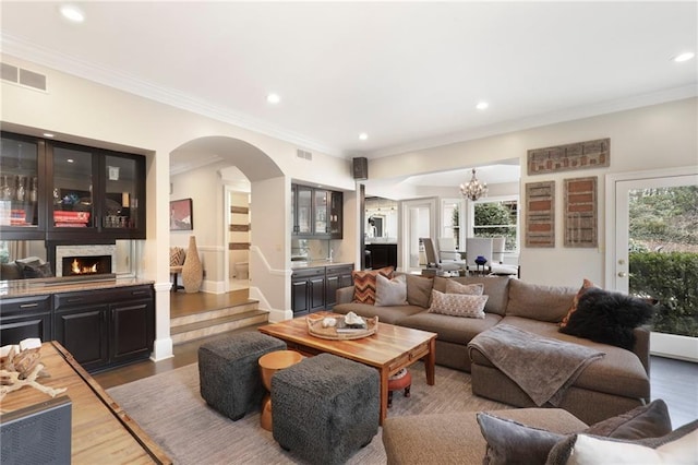 living room featuring crown molding, an inviting chandelier, and hardwood / wood-style flooring