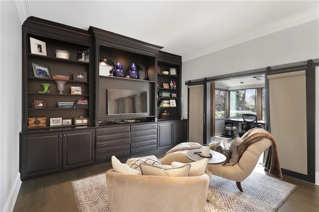 living area with a barn door, crown molding, and dark wood-type flooring