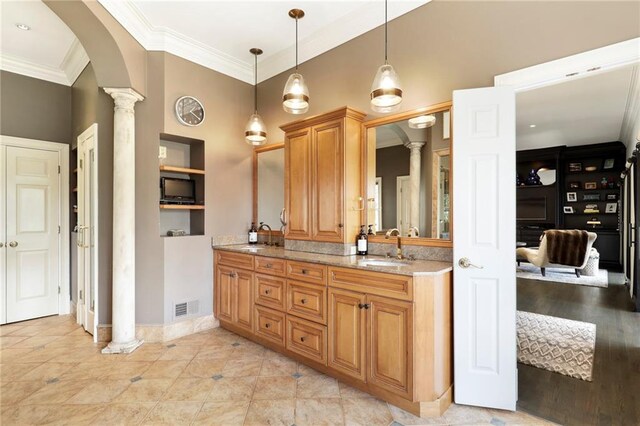 bathroom featuring ornate columns, tile flooring, vanity with extensive cabinet space, double sink, and ornamental molding