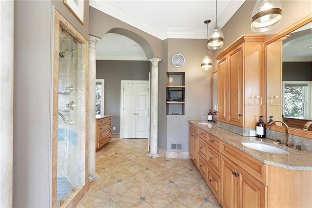 bathroom featuring tile flooring, ornate columns, tiled shower, and vanity