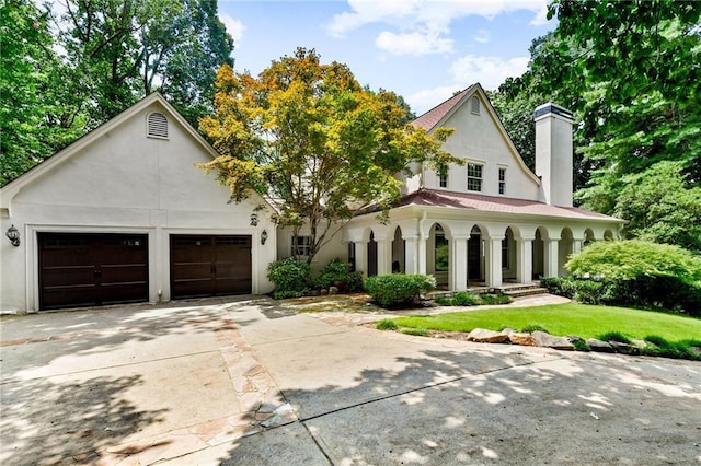 view of front of property featuring a front yard, covered porch, and a garage